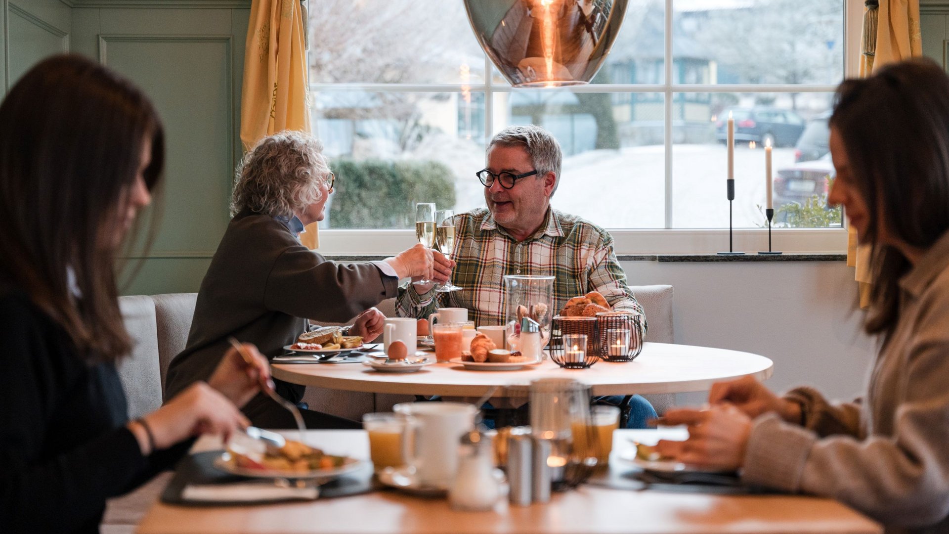 Breakfast in Rattenberg Older couple clinking champagne glasses during a cozy breakfast