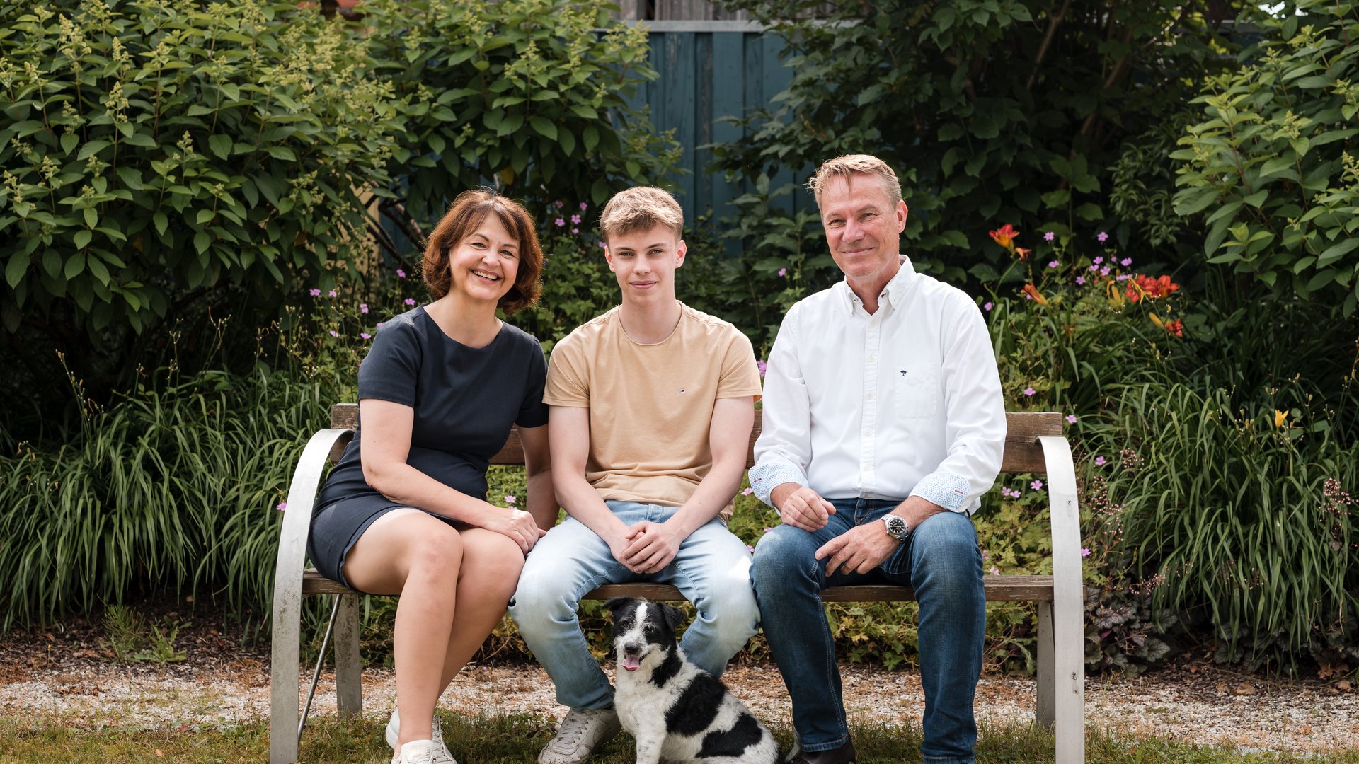 From the heart: your hosts Family with mother, father, son, and dog sitting on a bench in the garden